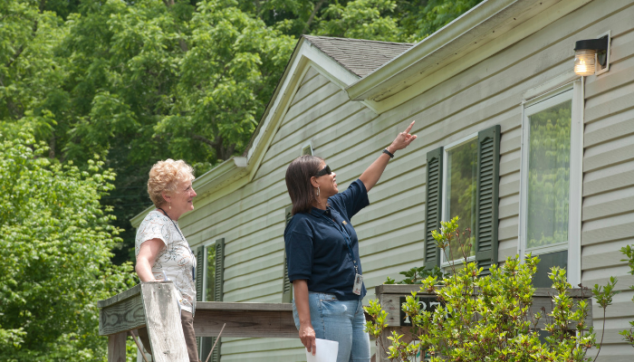 two women pointing at the outside of a house