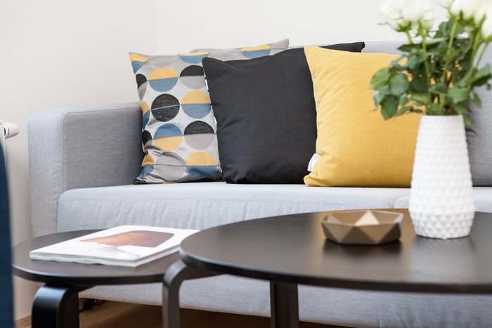 grey couch with yellow pillows