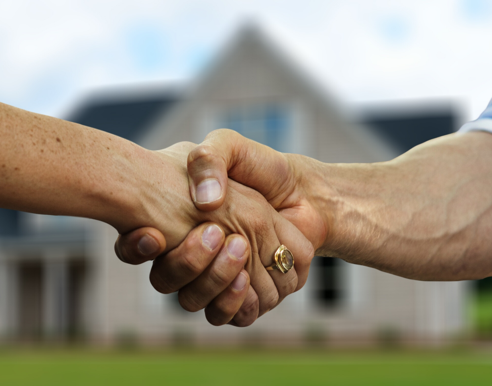 handshake between 2 people with a house in the background